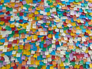 Un mur entièrement recouvert de petits papiers de couleur épinglés les uns à côté des autres